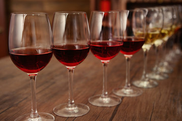 Many glasses of different wine in a row on bar counter