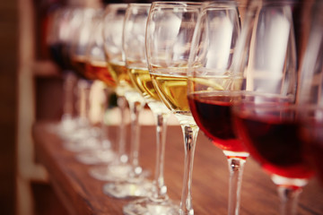 Many glasses of different wine in a row on bar counter
