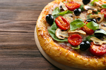 Delicious tasty pizza with ingredients on wooden table