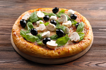Delicious tasty pizza with ingredients on wooden table