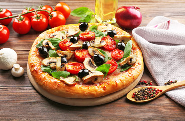 Delicious tasty pizza with ingredients on wooden table
