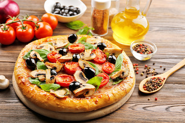 Delicious tasty pizza with ingredients on wooden table