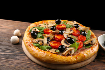 Delicious tasty pizza with ingredients on wooden table