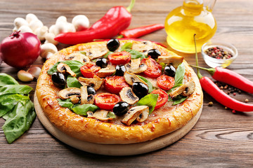 Delicious tasty pizza with ingredients on wooden table