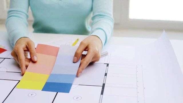 woman with blueprint and swatches choosing color