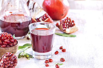 Pomegranate juice   with seeds on a white  vintage background.