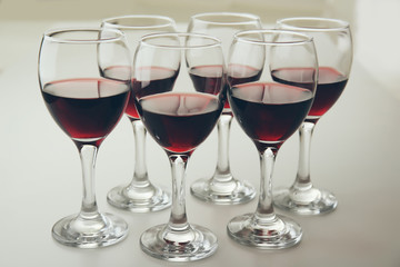 Glasses of red wine on white table closeup