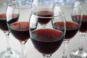 Glasses of red wine on white table closeup