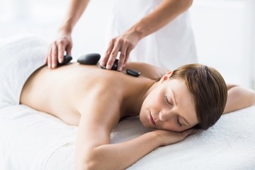 Obraz na płótnie Canvas Relaxed woman receiving hot stone massage