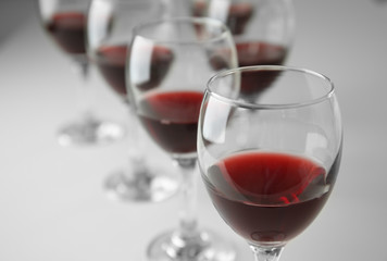 Glasses of red wine on white table closeup