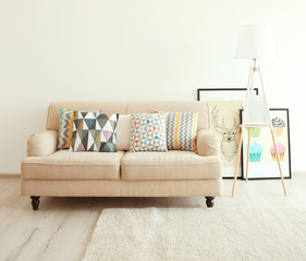 Beige couch and lamp on white wall background