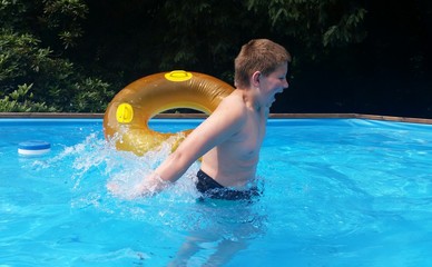 Kind mit Schwimmreifen im Pool