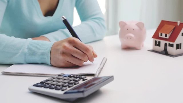 woman counting on calculator and taking notes