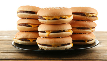Tasty cheeseburgers on plate, isolated on white