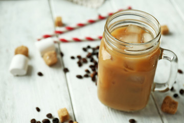 Iced coffee with milk on wooden background