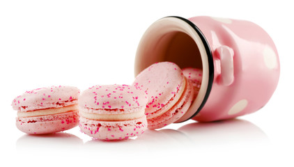 Tasty macaroons in cup, isolated on white