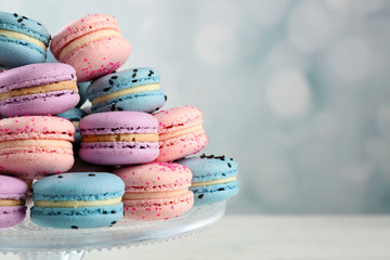 Tasty macaroons on stand on wooden table