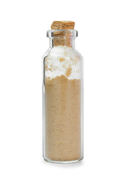 Powdered ginger in glass bottle on white background