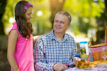 Father with daughter  enjoying on picnic sitting on a bench
