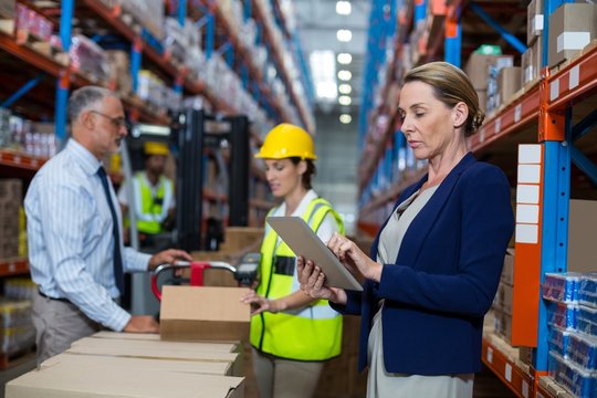 Business woman standing in front warehouse worker in warehouse