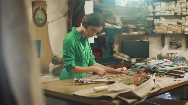 Young Woman Fashion Designer Works in Studio. Using Measuring Tape.