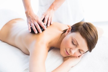 Beautiful woman enjoying hot stone massage