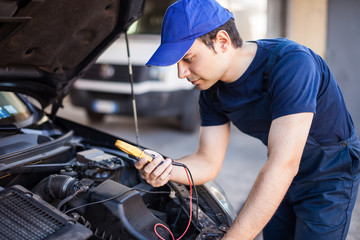 Auto electrician working on a car engine