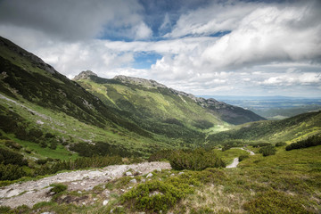 Europe, Poland, Polish high Tatras. The trail between two mountain range, cloudy sky, summer, green mountain forest