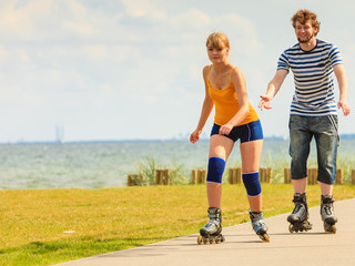 Young couple on roller skates riding outdoors