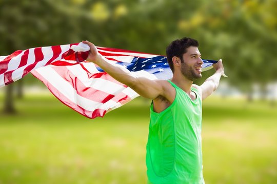 Composite image of happy sportsman holding a american flag 