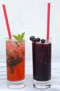 Two glasses of summer drink with ice on wood background