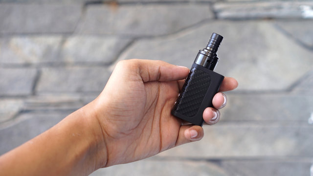 Man Hand Holding the Smallest Vaporizer In the World