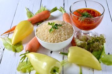 Healthy Eating, pepper, carrots and rice on a wooden table.