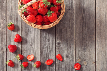 strawberries in basket on wooden background