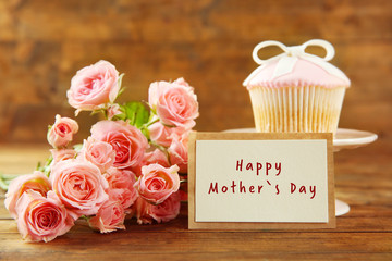 Happy Mothers Day. Fresh roses and present on wooden background