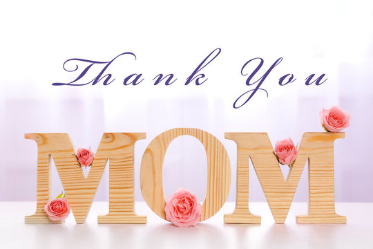 Happy Mothers Day. Mom word with flowers on light background.