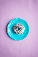 Obraz premium donut with chocolate, top view, colored background