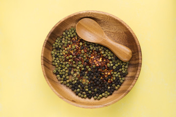 Wood spoon and dish on yellow background
