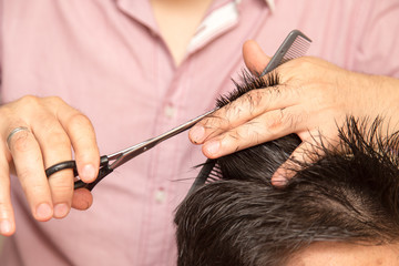 men's haircut with scissors at salon