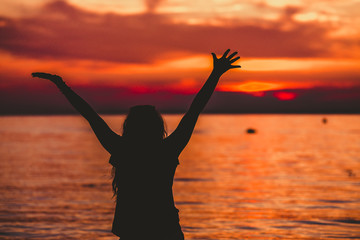 Obraz premium Happy Woman opening hands to sunset