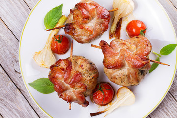 Pork rolls with cherry tomatoes and garlic. View from above, top studio shot