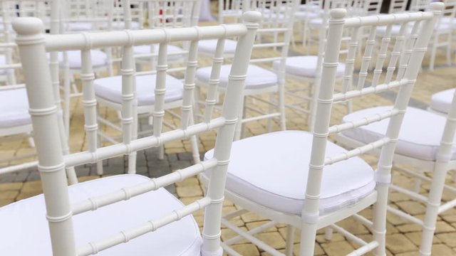 Dolly of rows of chairs at a wedding ceremony from the aisle and from the back