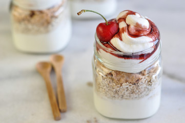 Yogurt with muesli and strawberry on a wooden table