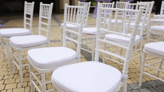 Dolly of rows of chairs at a wedding ceremony from the aisle and from the back