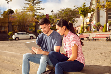 Obraz premium Young couple sitting in a town square