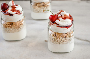 Yogurt with muesli and strawberry on a wooden table