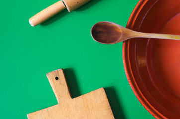 Set utensili da cucina in legno in pentola di coccio. Attrezzatura da cucina in sfondo verde