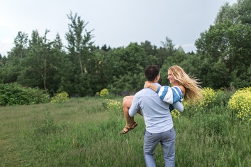 young guy turns girl on the hands on nature, the concept of love