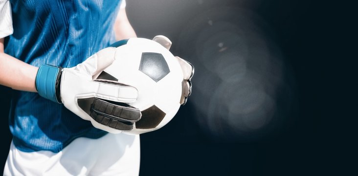 Composite image of close up of a football held by sportswoman 