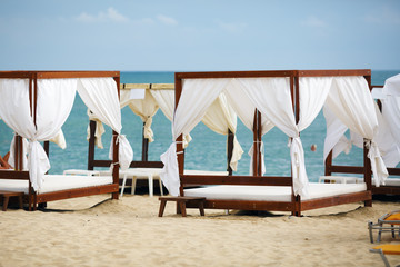 White beach canopies. Luxury beach tents at the resort for relaxation and spa treatments.